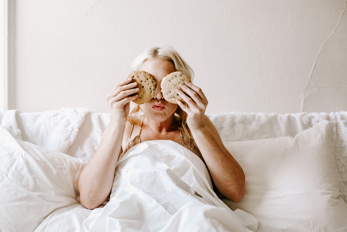 Food Cravings woman in bed with cookies